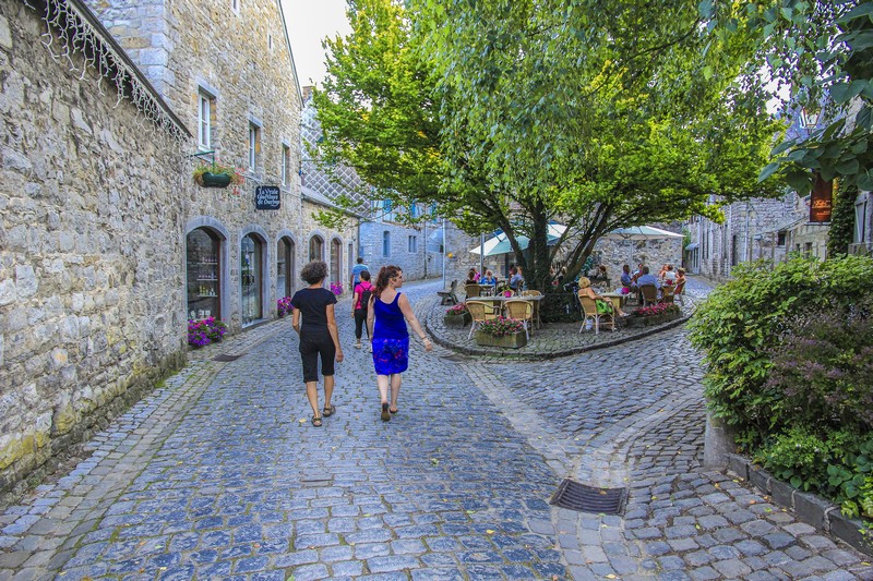 persone che passeggiano nelle strade acciottolate fra edifici di pietra della città vecchia