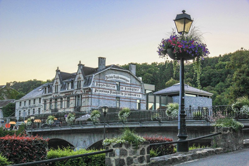 lampione con fiori in primo piano e edificio storico nella luce del tramonto