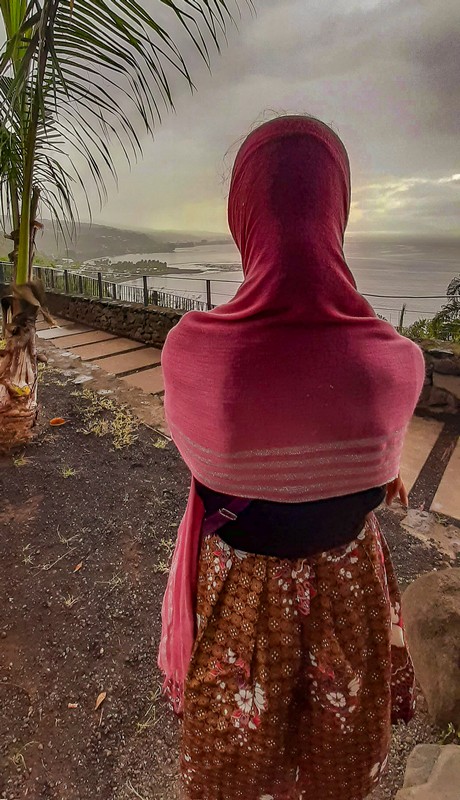 Ragazza si copre dalla pioggia guardando la terrazza panoramica e la costa sottostante