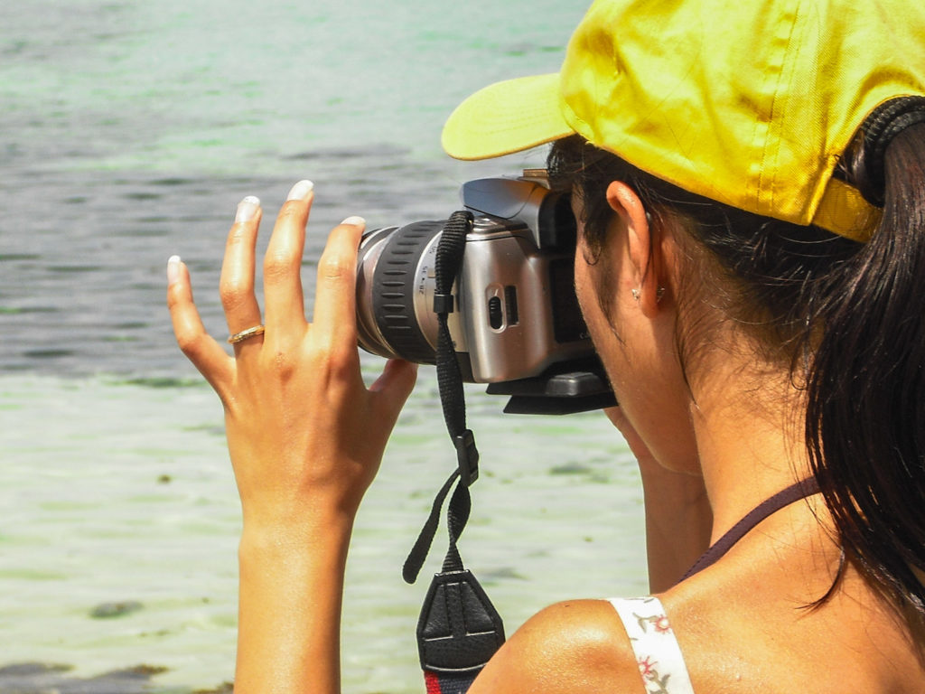 ragazza fotografa con vecchia reflex a pellicola