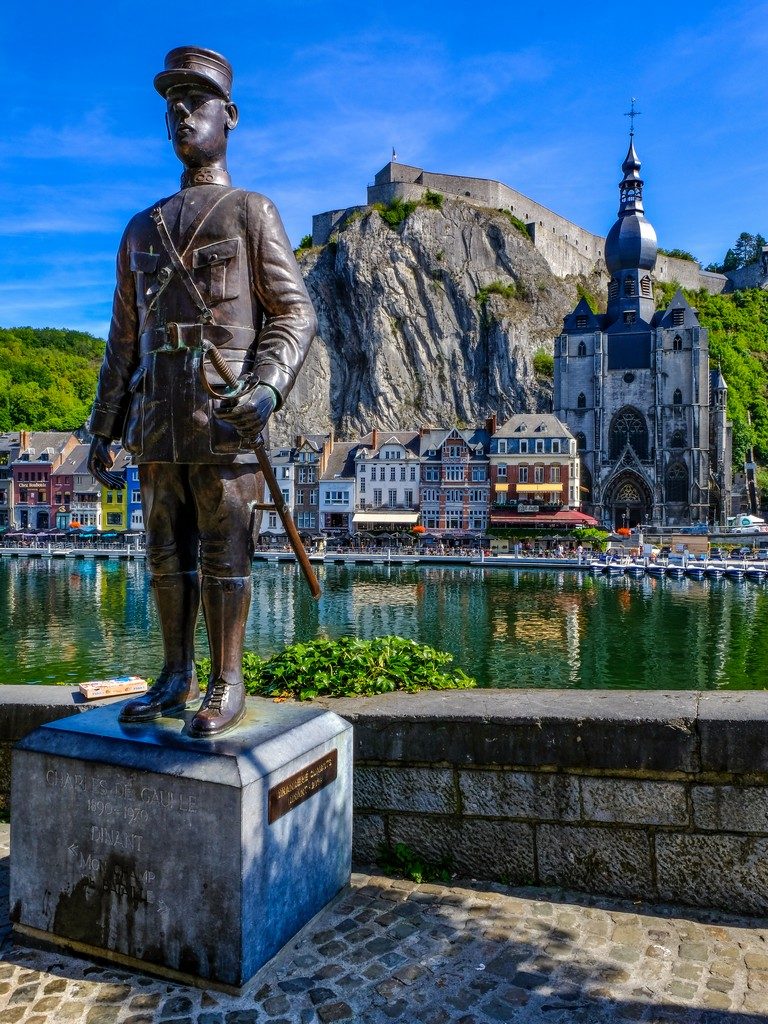 statua in primo piano con città dall'altra parte del fiume