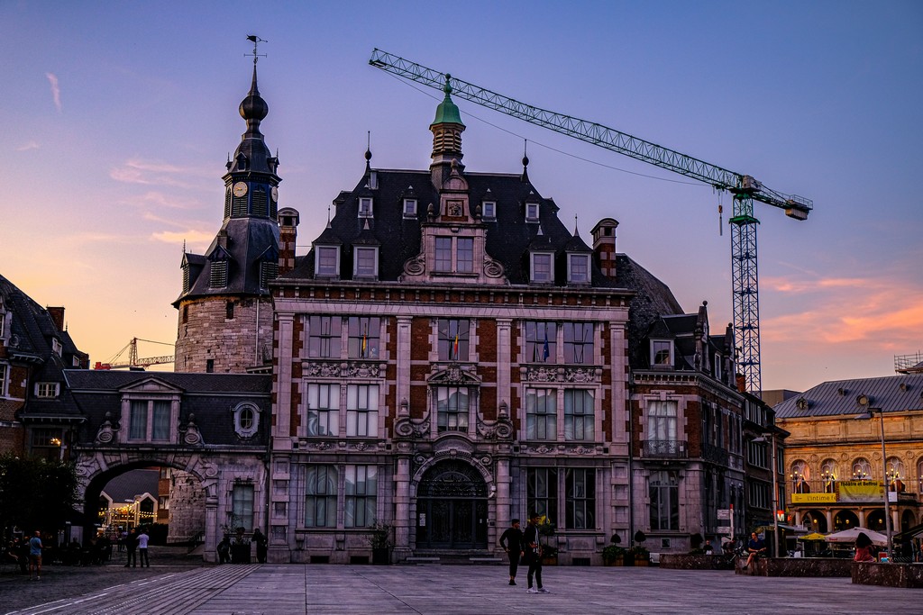 piazza principale con facciata di edificio e gru al tramonto