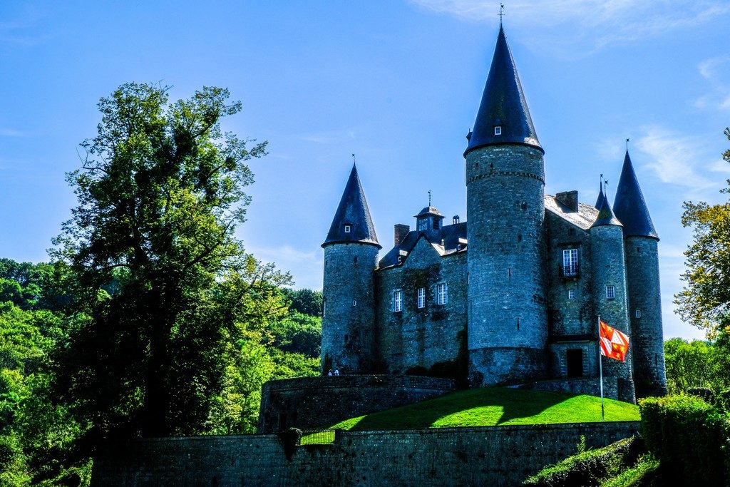 castello medievale in prato verde e cielo blu con bandiera