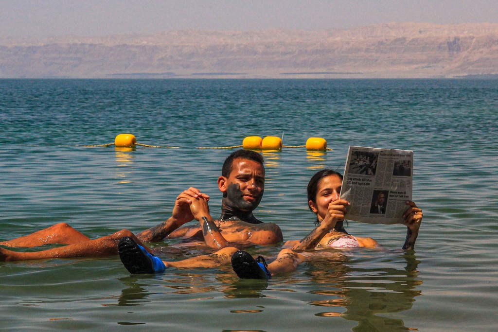 coppia legge il giornale galleggiando sull'acqua