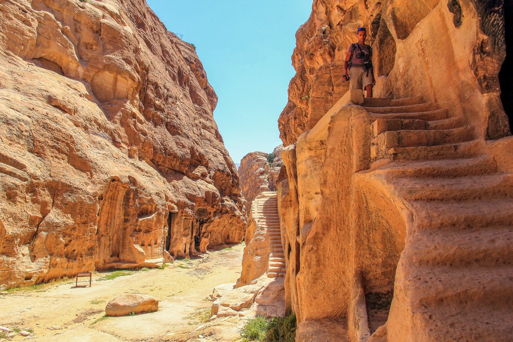 persona che scende dalla scalinata con altra scalinata in secondo piano dentro un canyon