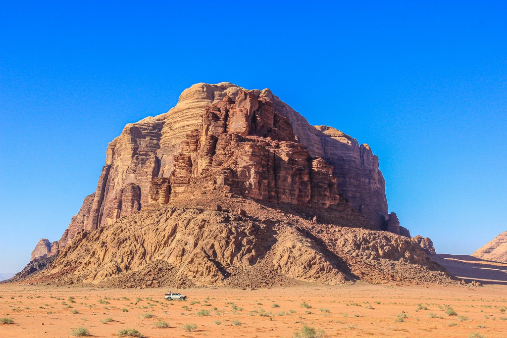 Guida al Wadi Rum sabbia rossa e colline rocciose del deserto giordano con auto