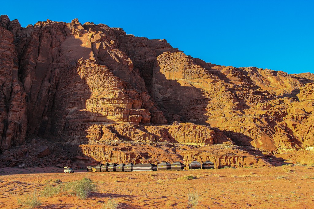 Guida al Wadi Rum sabbia rossa e colline rocciose del deserto giordano con tende beduine
