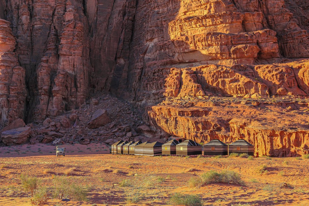 Guida al Wadi Rum sabbia rossa e colline rocciose del deserto giordano con accampamento beduino