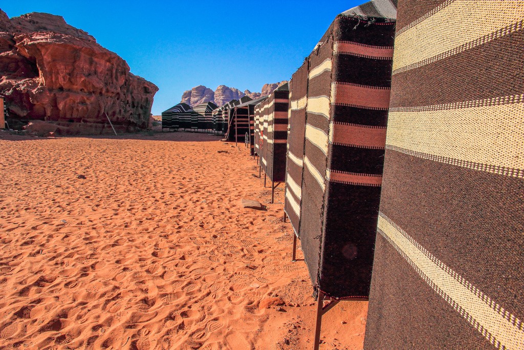 Guida al Wadi Rum sabbia rossa e colline rocciose del deserto giordano con tende di lana