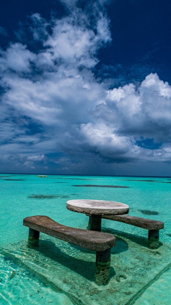 tavolo di pietra nell'acqua con nuvole