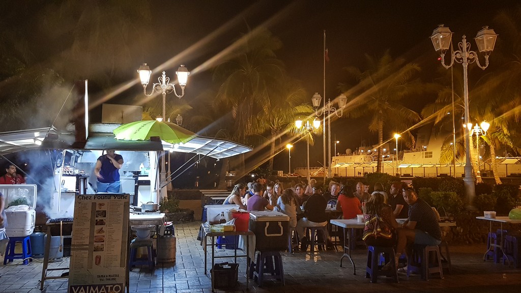 food truck all'aperto di sera con clienti seduti ai tavoli