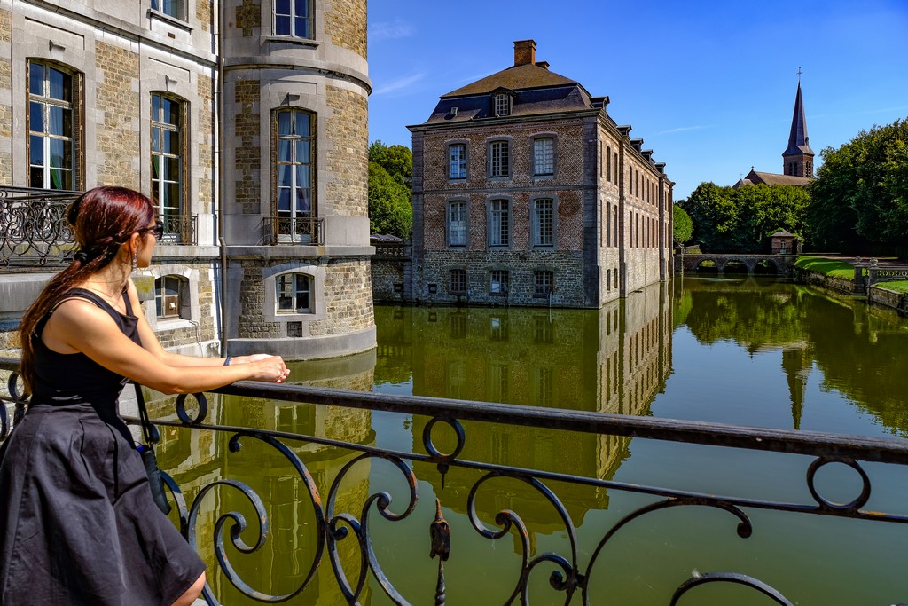 ragazza guarda il riflesso del castello nell'acqua con la chiesa in fondo