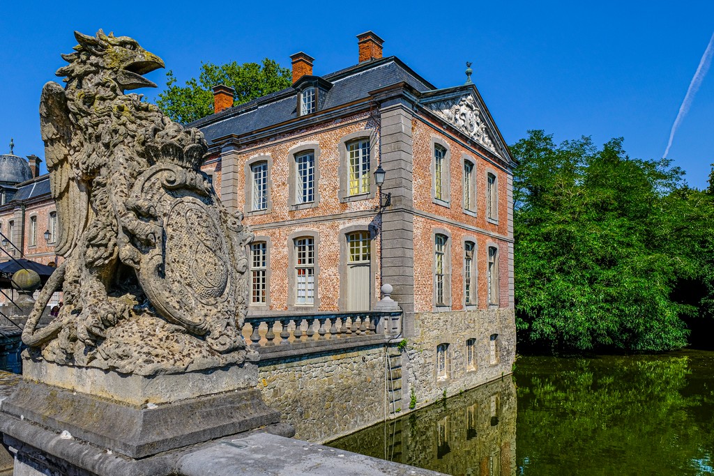 statua sopra al ponte sul fossato con in secondo piano il castello