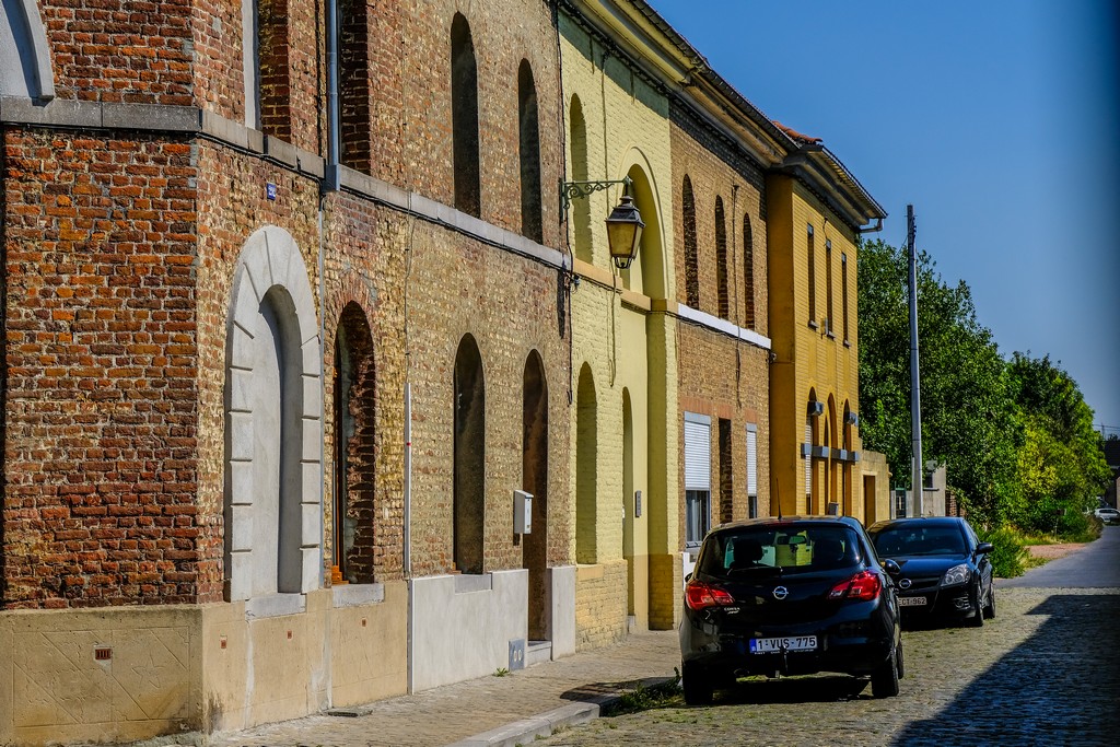 mura di mattoncini rossi e gialli con auto parcheggiate