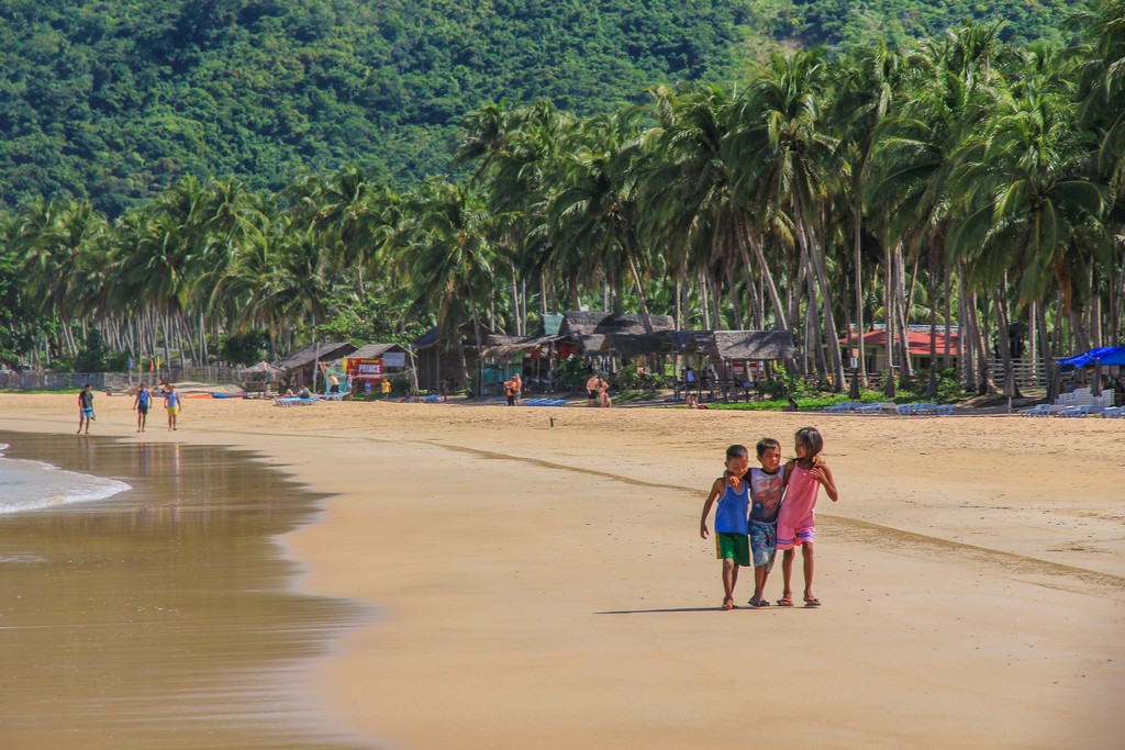 bambini in spiaggia con palme