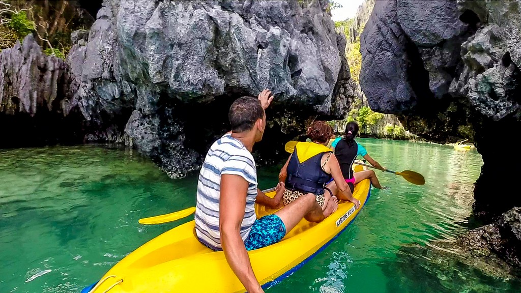 3 persone in kayak entrano in laguna chiusa da rocce