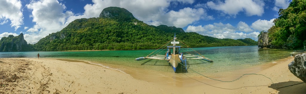 panorama di spiaggia con barca e montagna