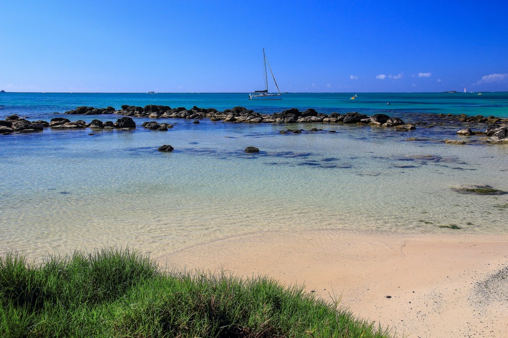 spiaggia con mare azzurro e sassi