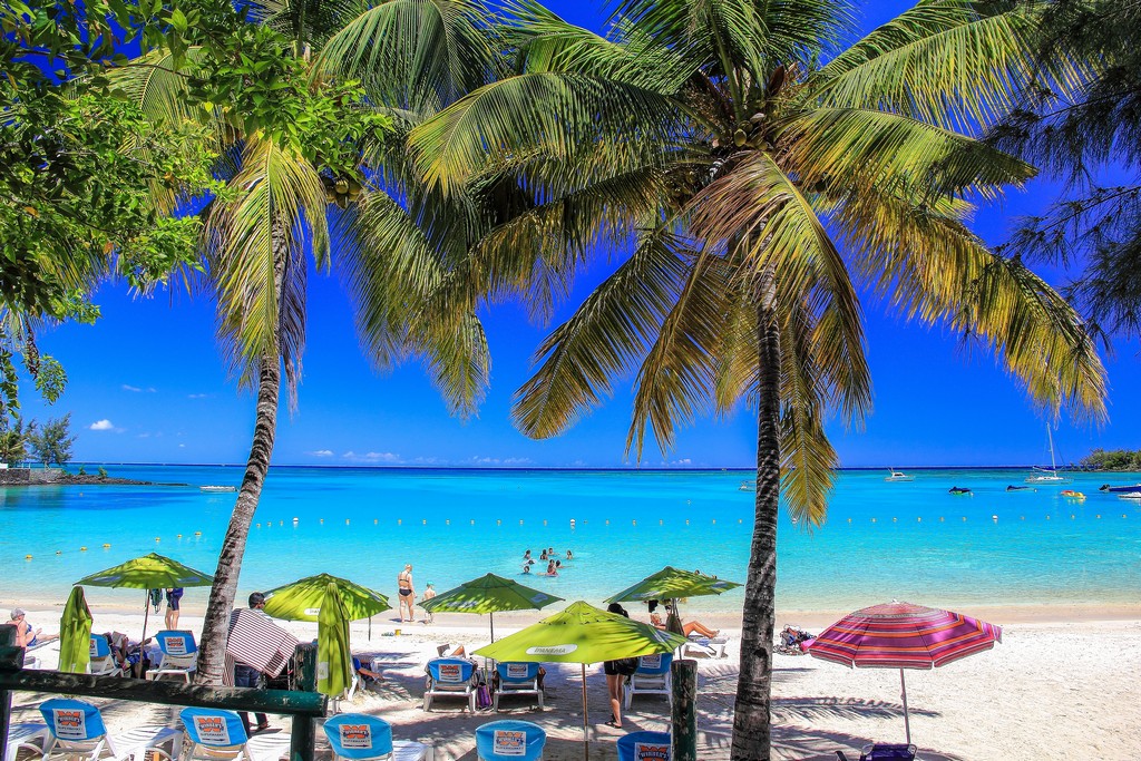 spiaggia con sabbia bianca ombrelloni e palme