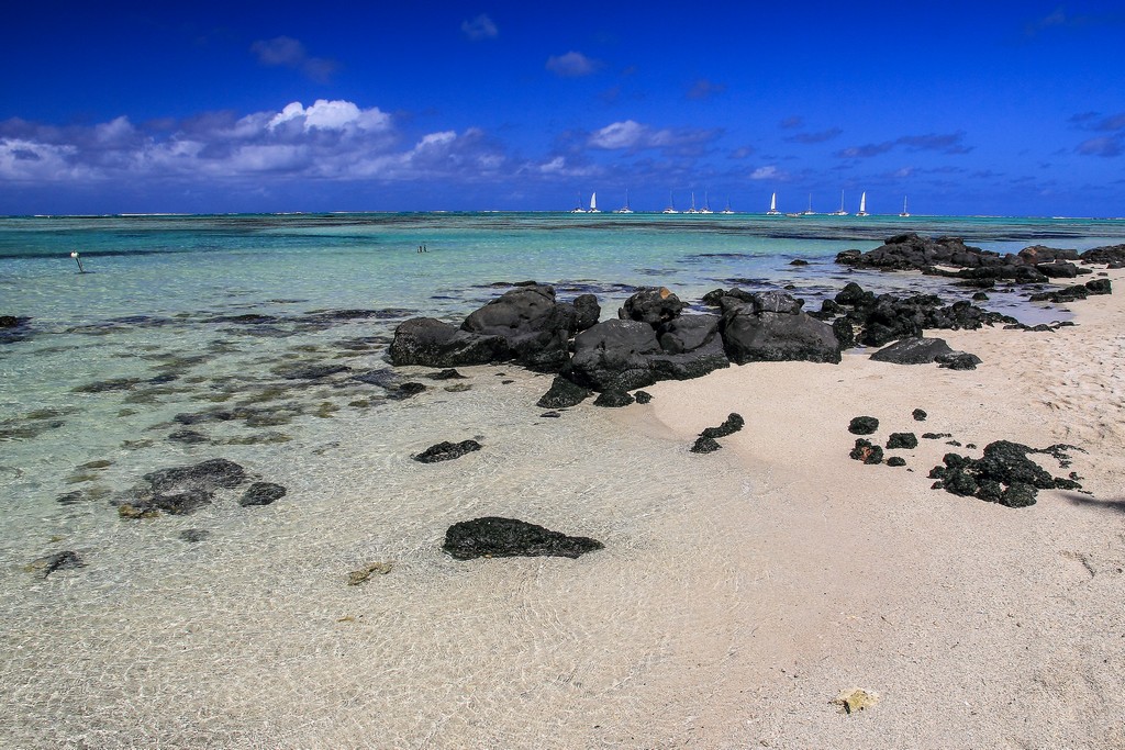 spiaggia con sassi neri e sabbia bianca