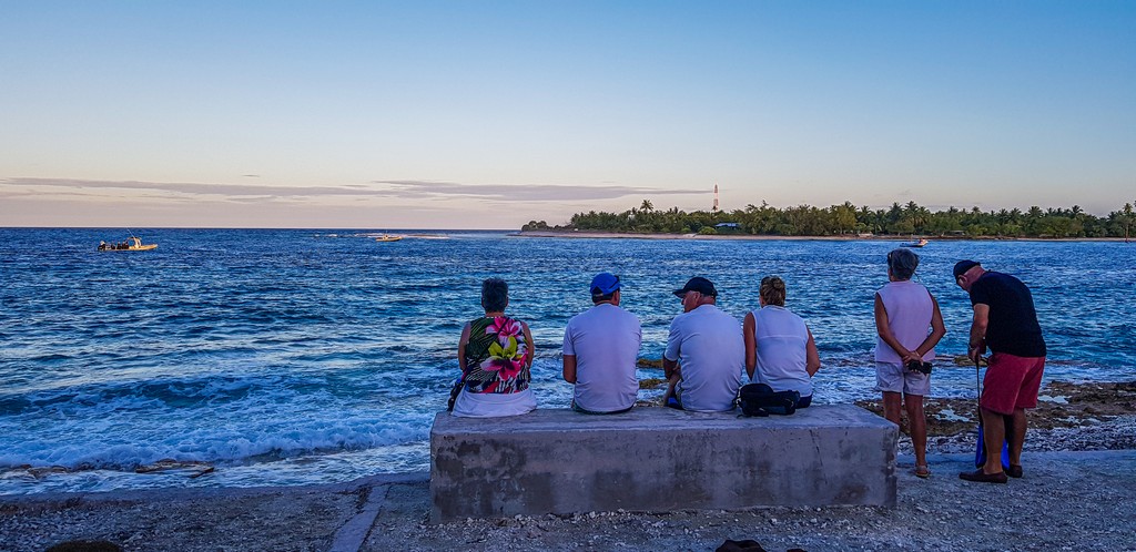 guida a Rangiroa, persone sedute davanti al mare al tramonto