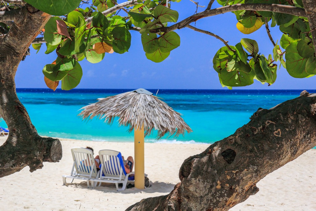 spiaggia di sabbia bianca con mare turchese con ombrellone e sdraio