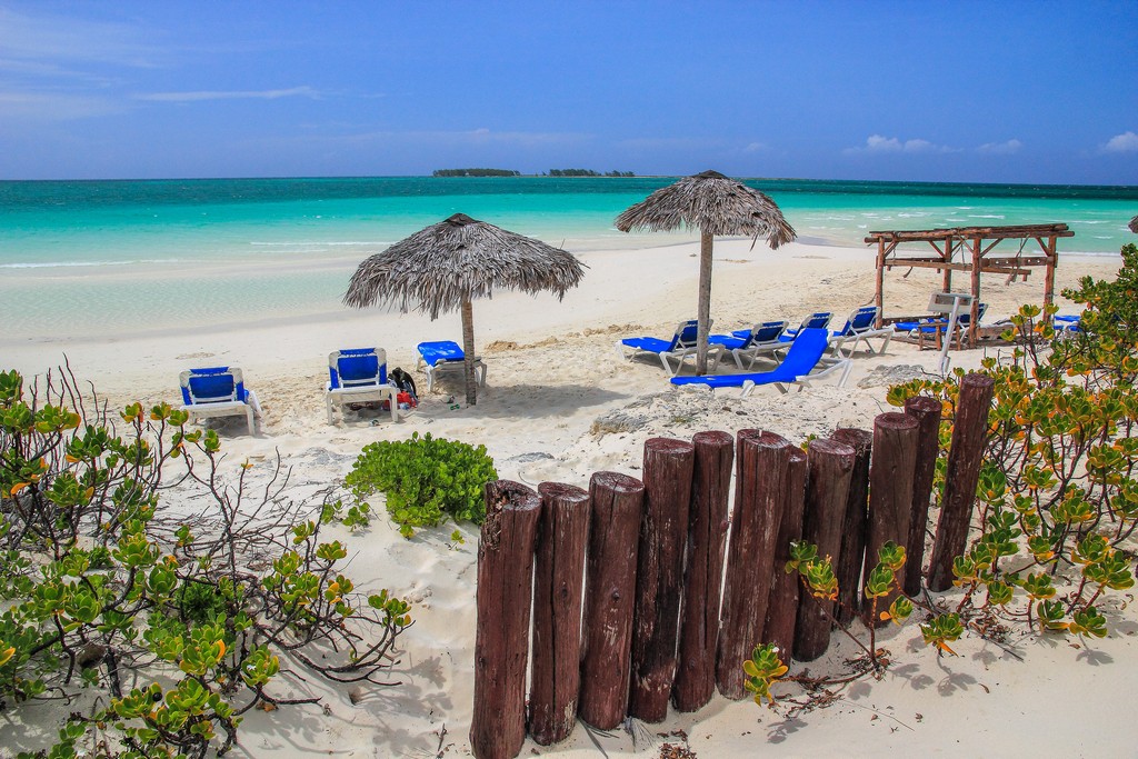 spiaggia di sabbia bianca con mare turchese sdraio e ombrelloni