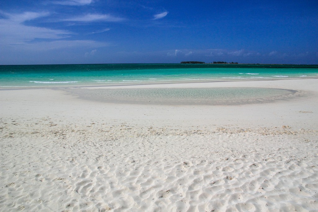 spiaggia di sabbia bianca con mare turchese e isole in fondo