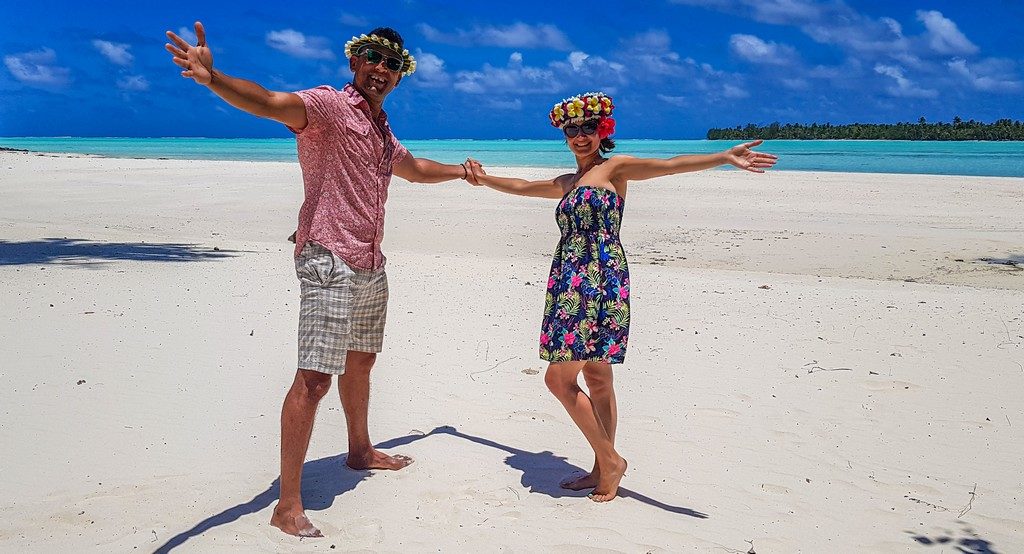 uomo e donna si tengono per mano in spiaggia