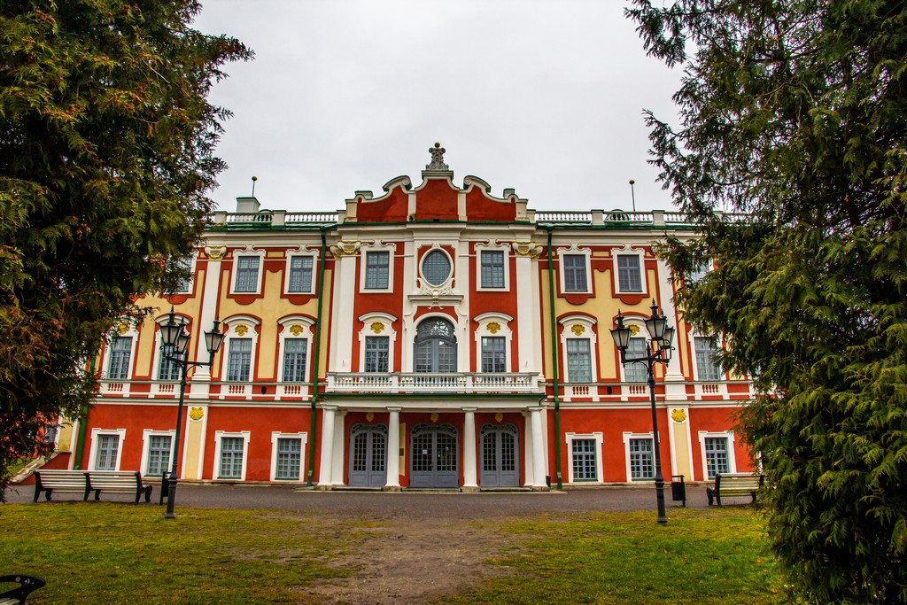 palazzo bianco e rosso dietro a due alberi