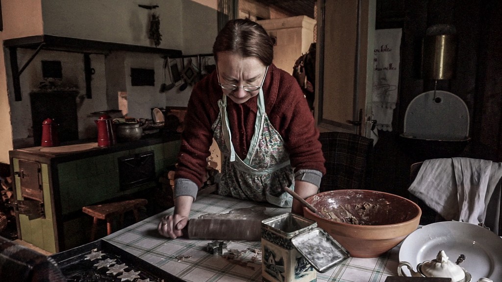 signora in abiti d'epoca che impasta i biscotti