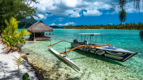 visitare la laguna di Bora Bora barca a bilaciere a lato della spiaggia