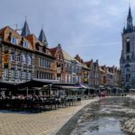 visita a tournai grand place con beffroi e case e sole vista frontale