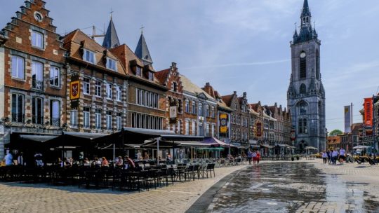 visita a tournai grand place con beffroi e case e sole vista frontale