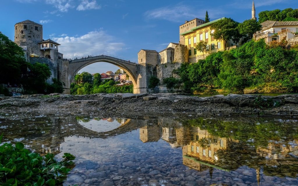 Cosa vedere a Mostar ponte vecchio di mostar riflesso in una pozza dacqua sulle rive