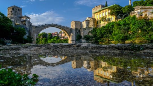 Cosa vedere a Mostar ponte vecchio di mostar riflesso in una pozza dacqua sulle rive