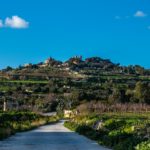 collina verde oltre la strada con cielo azzurro