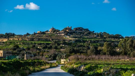 collina verde oltre la strada con cielo azzurro