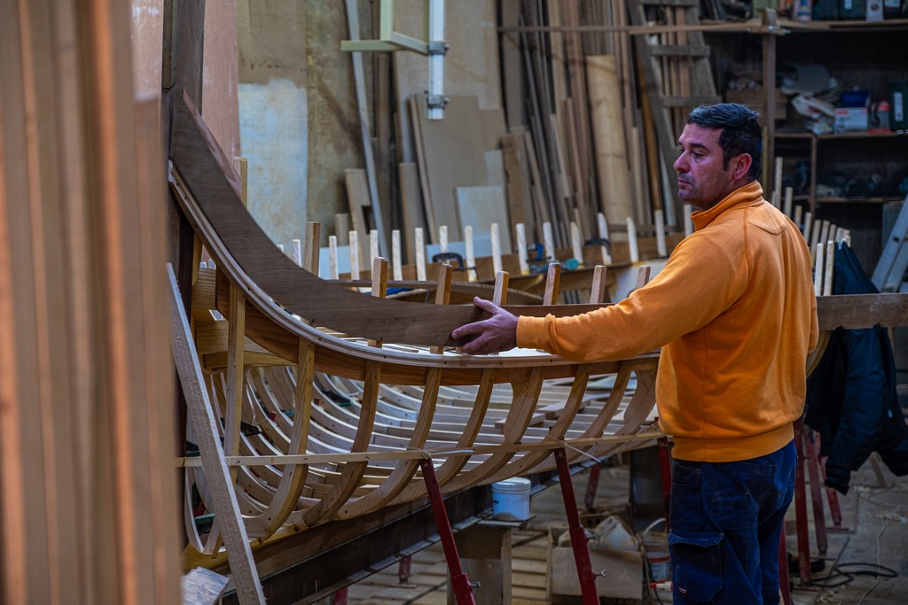 artigiano al lavoro per costruire una barca in officina