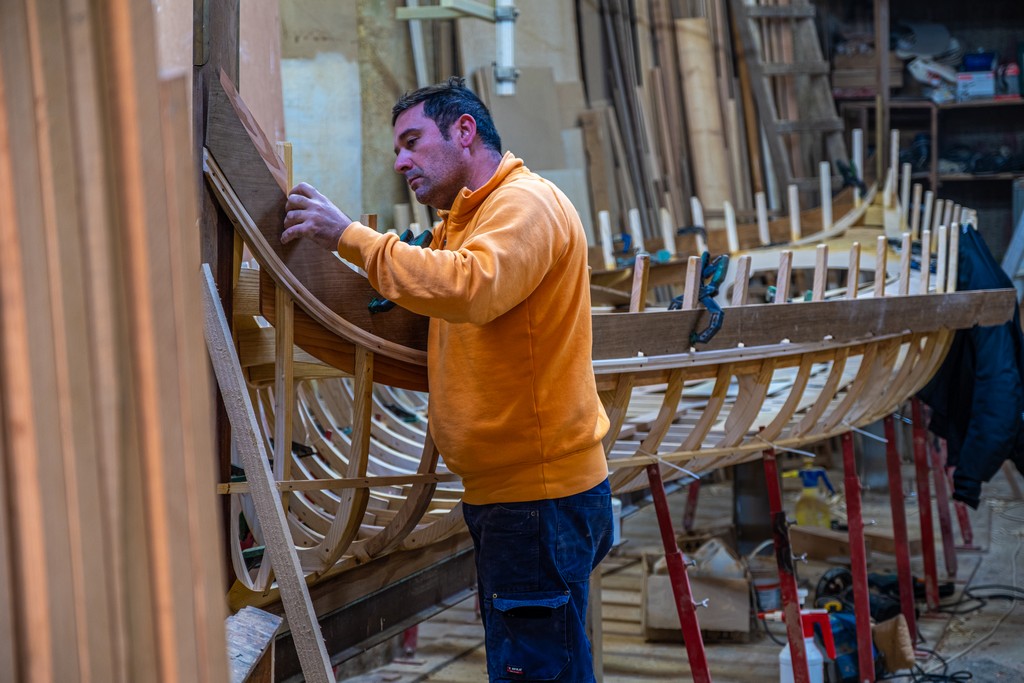 artigiano al lavoro per costruire una barca in officina