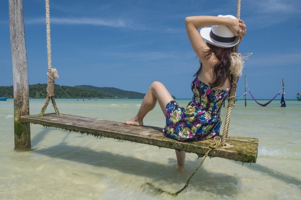 ragazza su altalena sul mare