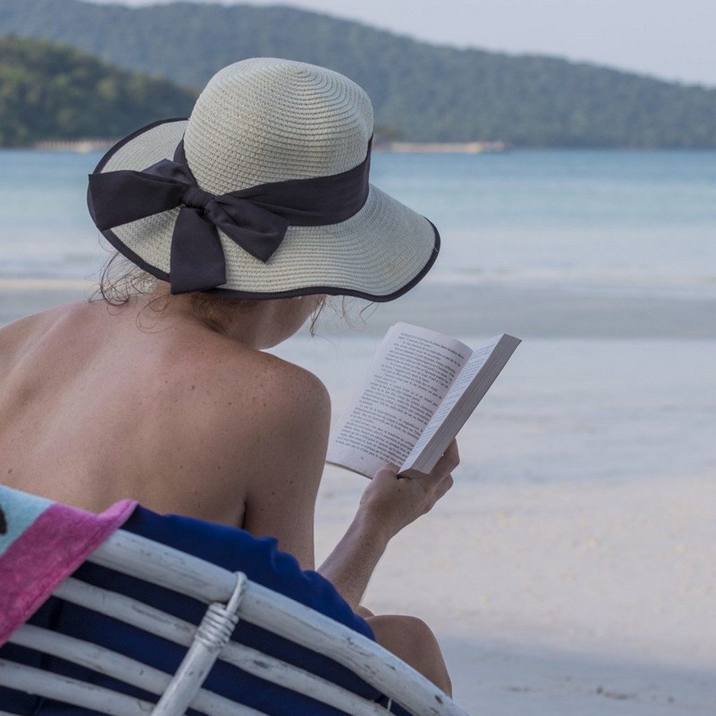 donna legge un libro in spiaggia