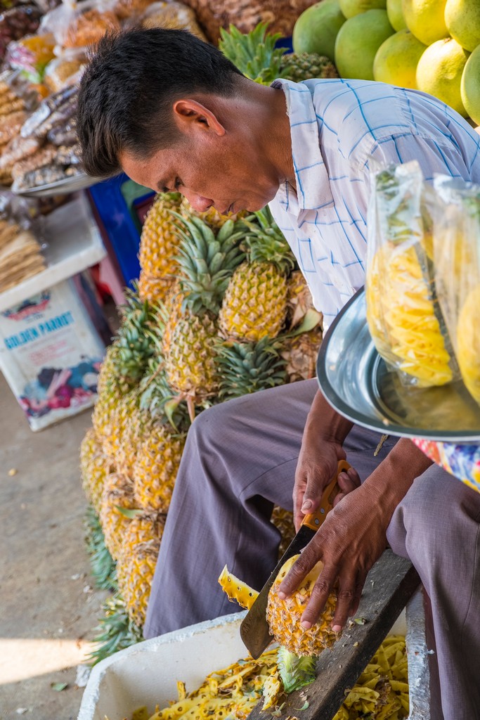 uomo sbuccia l'ananas