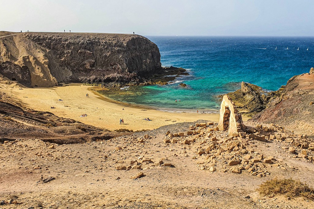 10 luoghi da non perdere a Lanzarote spiaggia a mezzaluna con scogliera